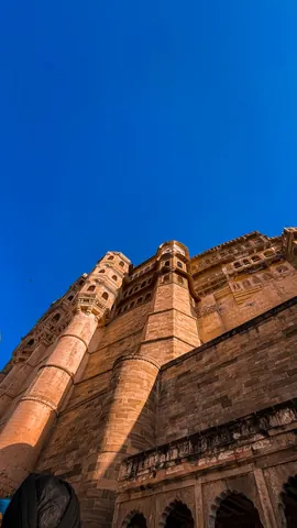 Sandstone walls rising into a deep blue sky.