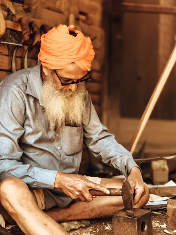 A carpenter at work among familiar tools.