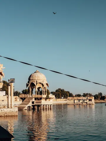 A domed pavilion beside still water.
