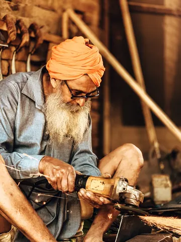 A carpenter guides a drill through his work.