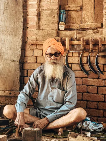 A craftsman seated among the tools of his trade.