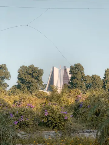 A distant monument framed by trees and open sky.