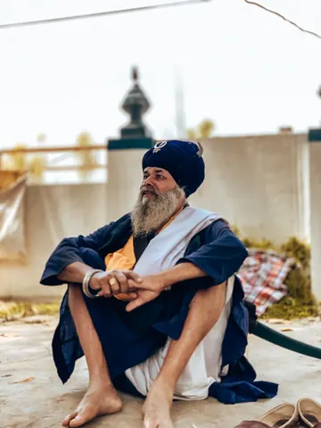 An elder sits at ease in the courtyard.