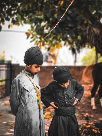 Two children share a moment beneath the trees.