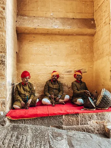Three musicians seated with their instruments.