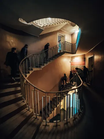 A curved staircase catches a shaft of light.
