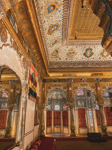 Painted ceilings and gilded details fill an ornate hall.