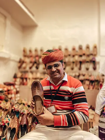 A shoemaker presents his work with a smile.