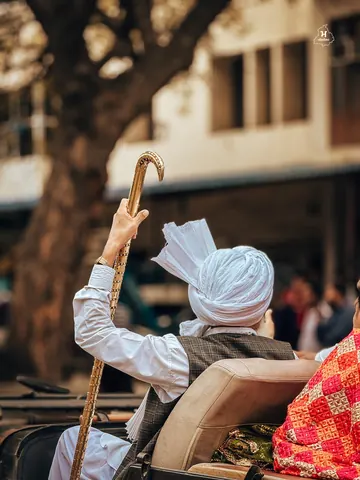 A raised walking stick catches the light above the crowd.