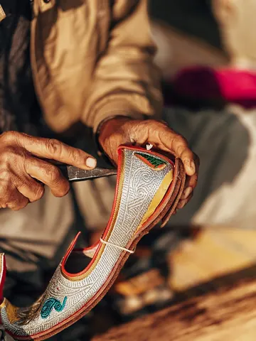 Colourful stitching follows the curve of a traditional shoe.