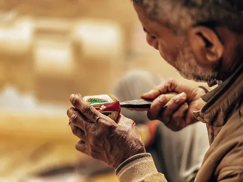 A shoemaker studies the details close to his hands.