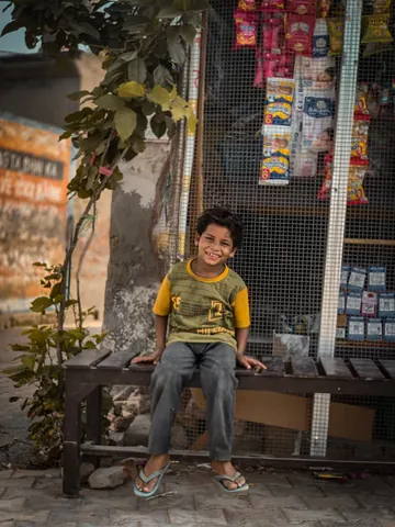 A quiet smile beneath the shade of the shopfront.