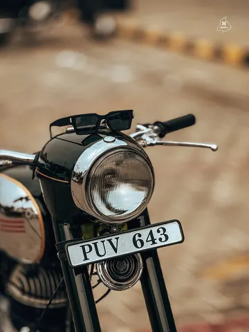 Sunglasses rest above the headlamp of a classic Jawa.