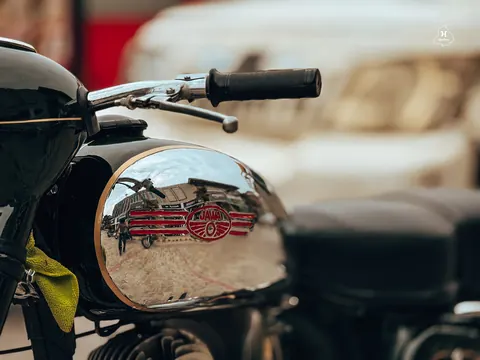 The street reflected in a polished Jawa fuel tank.