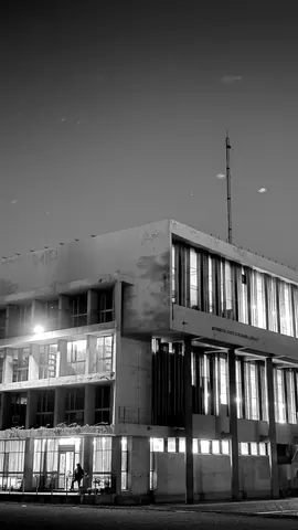 Library windows glow against the evening sky.