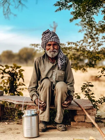 A moment of rest, with a milk can and walking stick close by.
