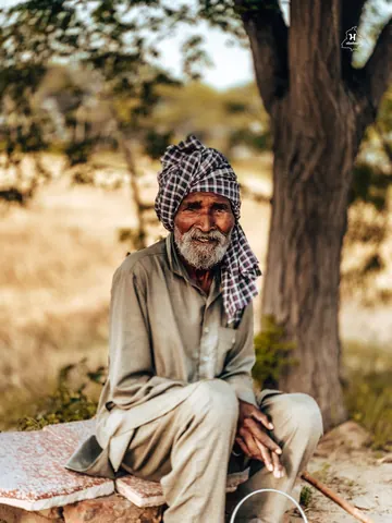 A warm smile in the shade of an old tree.