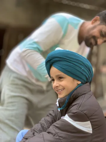 A bright smile beneath a freshly tied turban.