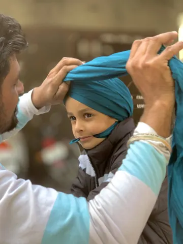 Care in every fold as a young boy's turban takes shape.